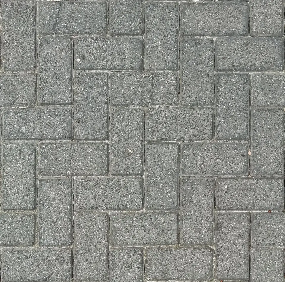 Herringbone pattern of gray stone pavers photographed from above