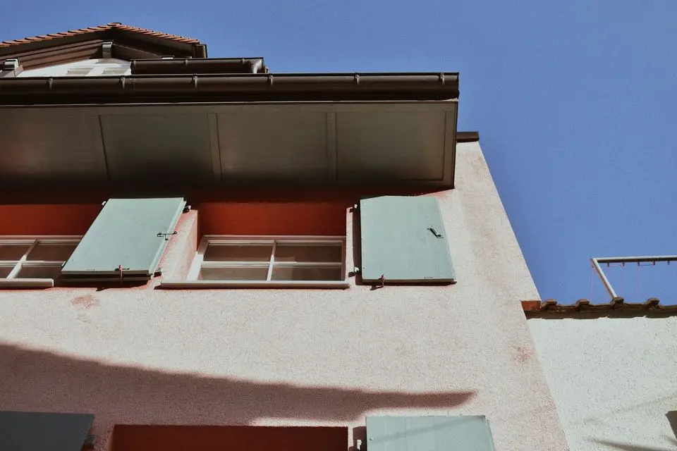 Stucco exterior with deep eaves and green shutters