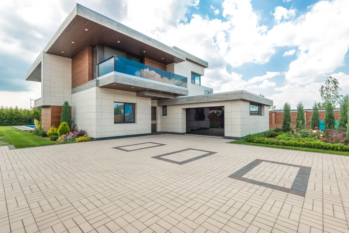 Modern home with a wide, clean paver driveway leading to the garage