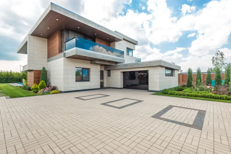 Modern home with a wide, clean paver driveway leading to the garage