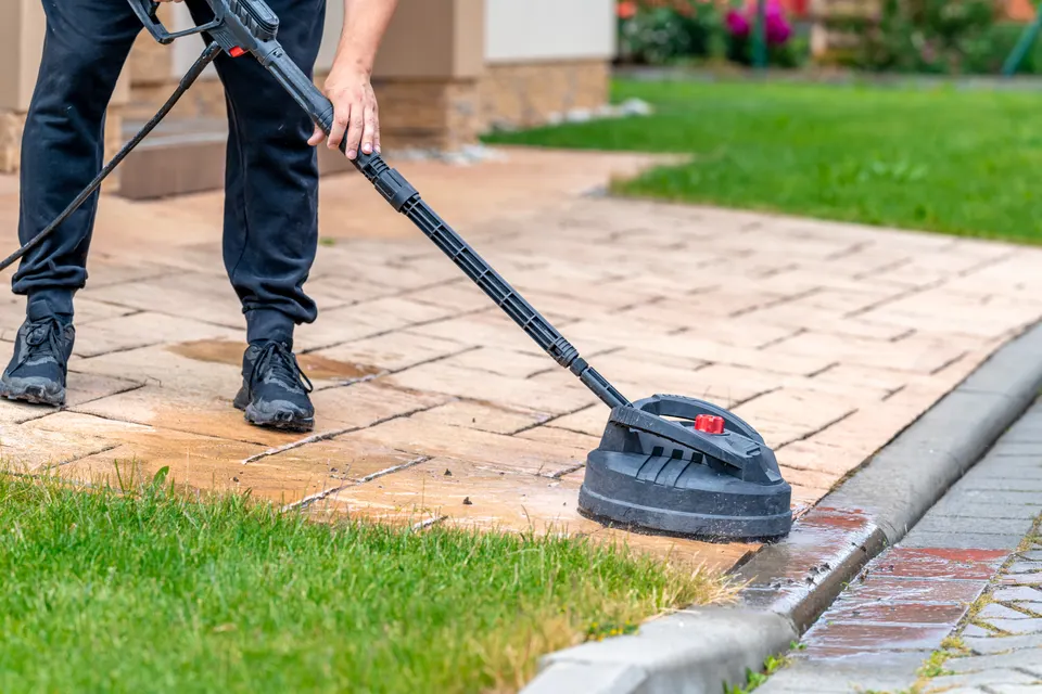 Commercial surface cleaner cutting a clean arc through grime on concrete